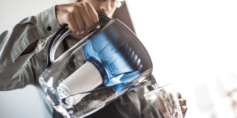 A glass water pitcher in use.
